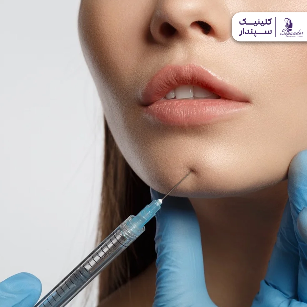 فردی که در حال تزریق چربی با سرنگ به پوست صورت و چانه است